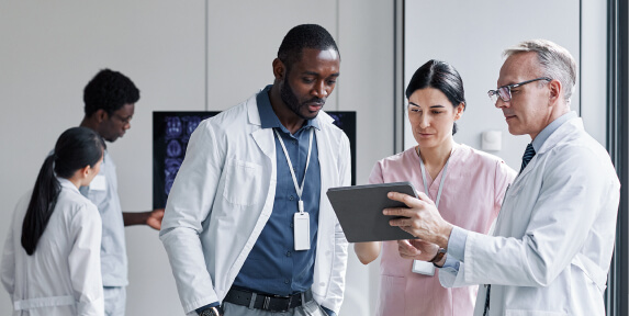 group of pharmaceuticals looking at a tablet